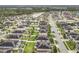 Aerial view of a community with neatly arranged homes, green spaces, and a serene lake at 10840 Cabbage Tree Loop, Orlando, FL 32825