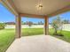 Covered back porch overlooking the large, well-maintained backyard with lush green grass and privacy fence at 10840 Cabbage Tree Loop, Orlando, FL 32825