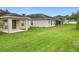 Wide-angle backyard with a covered porch and spacious grassy area, perfect for outdoor activities at 10840 Cabbage Tree Loop, Orlando, FL 32825