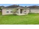 A backyard featuring a covered porch, lawn, landscaping, and partial view of the house's rear exterior at 10840 Cabbage Tree Loop, Orlando, FL 32825