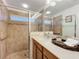 Bright bathroom featuring a sink, granite countertop, and glass-enclosed tiled shower at 10840 Cabbage Tree Loop, Orlando, FL 32825