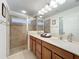 Bright bathroom featuring double sinks, granite countertop, and glass-enclosed tiled shower at 10840 Cabbage Tree Loop, Orlando, FL 32825