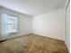 Carpeted bedroom with a window and white walls at 10840 Cabbage Tree Loop, Orlando, FL 32825