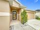 Home's front entrance featuring a decorative tree, leading to a welcoming front door at 10840 Cabbage Tree Loop, Orlando, FL 32825