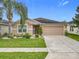 Charming single-story home with a manicured lawn, mature landscaping, and a two-car garage at 10840 Cabbage Tree Loop, Orlando, FL 32825