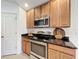 Close-up of kitchen appliances in a kitchen featuring wood cabinets and granite counters at 10840 Cabbage Tree Loop, Orlando, FL 32825