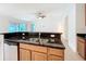 Kitchen sink with granite countertop and stainless steel dishwasher, next to living area at 10840 Cabbage Tree Loop, Orlando, FL 32825