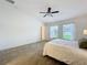 Cozy main bedroom with carpet, two windows, ceiling fan, and an ensuite bathroom at 10840 Cabbage Tree Loop, Orlando, FL 32825