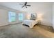 Bright main bedroom with carpet, two windows, ceiling fan, and lamps on end tables at 10840 Cabbage Tree Loop, Orlando, FL 32825