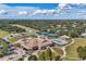 Aerial view of a country club featuring tennis courts, a swimming pool, and lush golf courses at 11237 Camden Park Dr, Windermere, FL 34786