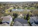 Overhead shot of neighborhood homes with a large lake featuring a fountain, surrounded by mature trees and lush landscaping at 11237 Camden Park Dr, Windermere, FL 34786