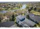 Panoramic aerial shot of neighborhood homes with a community lake featuring a fountain surrounded by mature trees at 11237 Camden Park Dr, Windermere, FL 34786