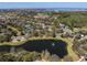 Expansive aerial view of a neighborhood featuring a serene pond with a fountain and lush landscaping at 11237 Camden Park Dr, Windermere, FL 34786