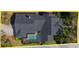 Detailed aerial shot of a home with a screened-in pool, set amidst lush greenery and landscaping at 11237 Camden Park Dr, Windermere, FL 34786