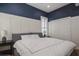 Bedroom with decorative blue accent wall, white trim and a large window at 11237 Camden Park Dr, Windermere, FL 34786