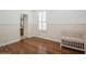 A minimalist bedroom with hardwood floors, white paneled walls, plantation shutters, and a classic crib at 11237 Camden Park Dr, Windermere, FL 34786