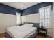 A stylish bedroom with navy upper walls, plantation shutters, and a bed with matching bedside tables and lamps at 11237 Camden Park Dr, Windermere, FL 34786