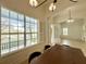 Bright dining room with large windows offering serene water views and elegant light fixtures at 11237 Camden Park Dr, Windermere, FL 34786