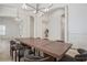 Open dining room with a large wood table, modern chandelier, and white pillars at 11237 Camden Park Dr, Windermere, FL 34786