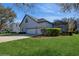 View of the house with a well-manicured lawn, a four-car garage, and a screened-in pool at 11237 Camden Park Dr, Windermere, FL 34786