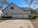 Spacious three-car garage, showcasing ample parking and a well-maintained exterior with lush landscaping at 11237 Camden Park Dr, Windermere, FL 34786