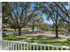 Picturesque view of a tranquil lake from the front porch, surrounded by mature trees and lush landscaping at 11237 Camden Park Dr, Windermere, FL 34786