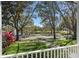 Serene lake view from a porch, accented by a lush green lawn and colorful foliage at 11237 Camden Park Dr, Windermere, FL 34786