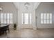 Elegant foyer featuring a chandelier, columns, high ceilings, a front door with sidelights, and neutral tile flooring at 11237 Camden Park Dr, Windermere, FL 34786