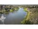 Scenic aerial view of a serene lake with a fountain, lined with green spaces, walking path, and verdant trees at 11237 Camden Park Dr, Windermere, FL 34786