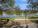 Tranquil lake view featuring a fountain, lush green spaces, walking path, bench, and mature trees at 11237 Camden Park Dr, Windermere, FL 34786