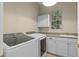 Well-equipped laundry room with washer, dryer, sink, and ample storage cabinets at 11237 Camden Park Dr, Windermere, FL 34786