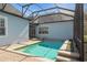 A refreshing, screened-in pool is surrounded by brick pavers and sits adjacent to the home's serene, light blue facade at 11237 Camden Park Dr, Windermere, FL 34786