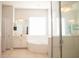 Bright bathroom features a glass shower, soaking tub, and tile floors at 11474 Claymont Cir, Windermere, FL 34786