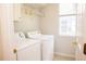 Functional laundry room featuring a washer, dryer, storage shelves, and a window at 11474 Claymont Cir, Windermere, FL 34786