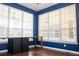 Bright room featuring blue walls, wood floors, and natural light streaming through large windows at 11474 Claymont Cir, Windermere, FL 34786
