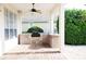 Outdoor kitchen with stone counter, built-in grill, and lush landscaping for backyard entertaining at 11474 Claymont Cir, Windermere, FL 34786