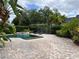 Beautiful pool with an attached jacuzzi and lounge chairs on a brick patio surrounded by lush landscaping and a fence at 11474 Claymont Cir, Windermere, FL 34786