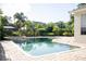 Backyard swimming pool and spa with lush landscaping and a black metal fence at 11474 Claymont Cir, Windermere, FL 34786