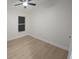 Bright bedroom with wood-look flooring, ceiling fan, and a large window for natural light at 1151 Myopia Hunt Club Dr, Auburndale, FL 33823