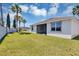 Backyard view featuring a screened lanai and manicured lawn with mature palm trees in the background at 1306 Windward Oaks Loop, Auburndale, FL 33823