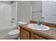 Clean bathroom features a shower-tub combo and a wooden vanity at 1306 Windward Oaks Loop, Auburndale, FL 33823