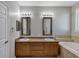 Bathroom featuring double sinks, framed mirrors, and a separate soaking tub at 1306 Windward Oaks Loop, Auburndale, FL 33823