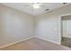 Neutral bedroom boasts a ceiling fan and attached closet at 1306 Windward Oaks Loop, Auburndale, FL 33823