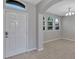 The bright foyer features tile flooring, an archway, and three windows letting in natural light at 1306 Windward Oaks Loop, Auburndale, FL 33823