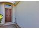 The entryway showcases a brown door with a small transom window and brick pavers at 1306 Windward Oaks Loop, Auburndale, FL 33823