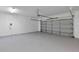 Garage with epoxy floor and large garage door allowing natural light at 1306 Windward Oaks Loop, Auburndale, FL 33823