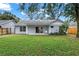 A well-maintained lawn is the focal point, surrounded by a gray home, windows, and an outdoor patio at 1341 American Elm Dr, Altamonte Springs, FL 32714