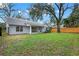 A spacious backyard with healthy lawn, privacy fence, mature trees, and a covered patio at 1341 American Elm Dr, Altamonte Springs, FL 32714