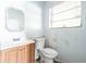 Bathroom with a sink, a toilet, a mirror, and a window with blinds at 1408 N Pine Hills Rd, Orlando, FL 32808