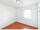 Bedroom featuring hardwood floors, white walls, and a window with natural light at 1408 N Pine Hills Rd, Orlando, FL 32808